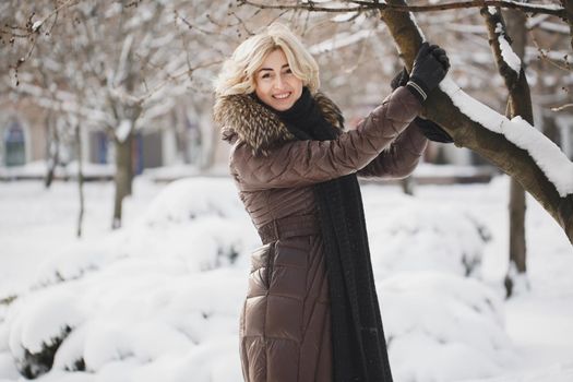 A beautiful woman posing in a winter park.