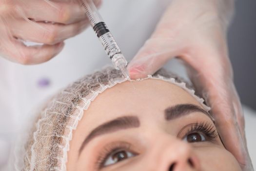 Cosmetic botox injection at the cosmetology medical center, close-up