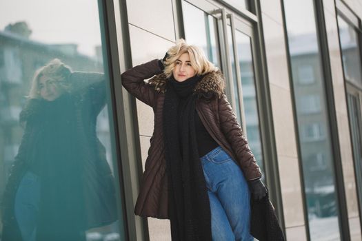 beautiful woman posing near the glass building