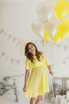 Beautiful pregnant woman in a yellow dress in the Studio.