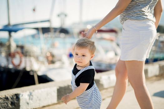 Happy mother and son on sea yacht background