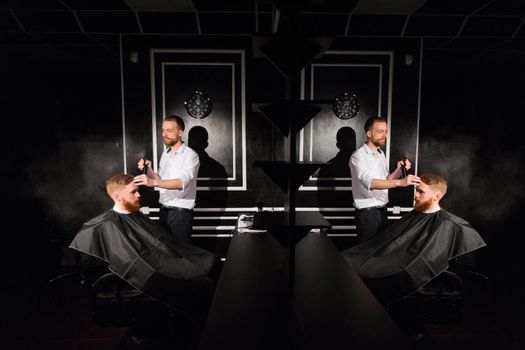 Spraying hair. Portrait of a barber spraying water on the hair of the client