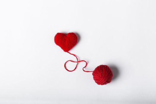 Close up of a wool ball and heart shape on white background. Heart shaped woolen yarn. Love Crochet.