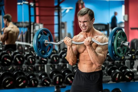 Very power athletic guy standing workout in the gym