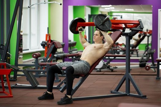 Man doing chest exercises on vertical bench press machine
