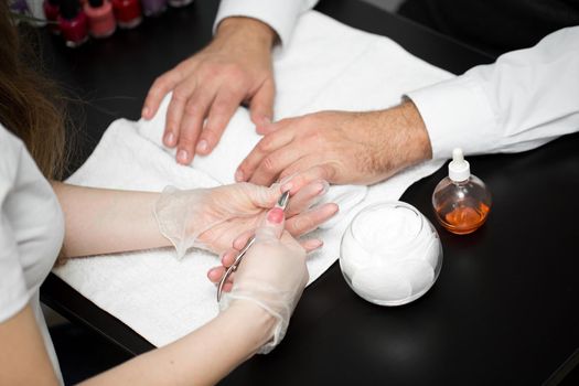 Close-up Of A Manicurist Cutting Off The Cuticle From The Person's Fingers