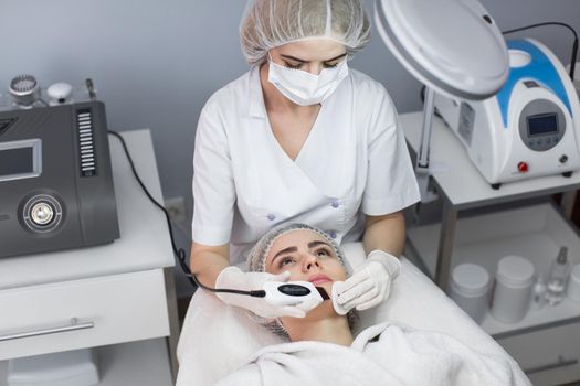 Skin Care. Close-up Of Beautiful Woman Receiving Ultrasound Cavitation Facial Peeling. Ultrasonic Skin Cleansing Procedure. Beauty Treatment. Cosmetology. Beauty Spa Salon.