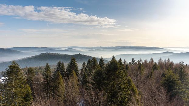 Foggy view of Beskid Sadecki mountain range in Poland on a sunny day