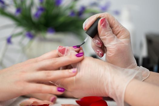 Manicure pink nail polish in the salon