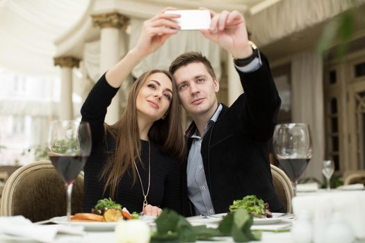 Beautiful couple taking selfie photo in a restaurant