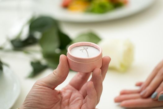 Man making marriage proposal to girlfriend at restaurant, closeup