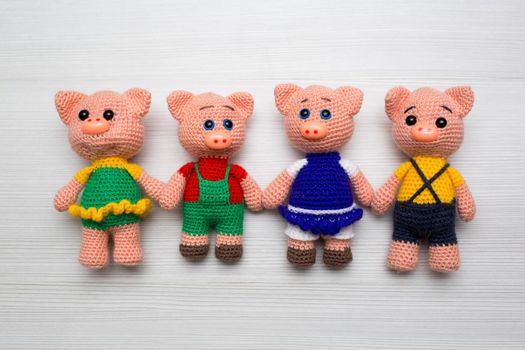 Knitted piglets toys for a child. A symbol of the New Year.