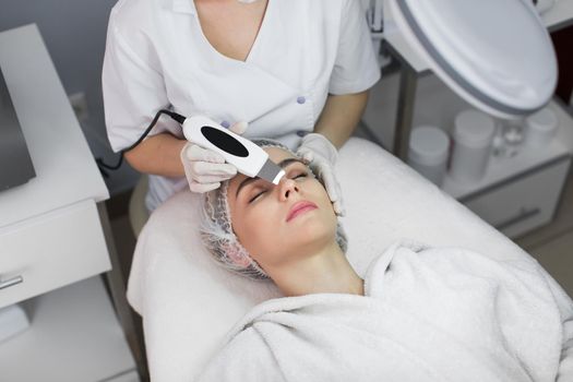 Skin Care. Close-up Of Beautiful Woman Receiving Ultrasound Cavitation Facial Peeling. Ultrasonic Skin Cleansing Procedure. Beauty Treatment. Cosmetology. Beauty Spa Salon.