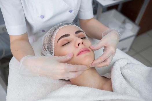 Skin And Body Care. Close-up Of A Young Woman Getting Spa Treatment At Beauty Salon. Spa Face Massage. Facial Beauty Treatment. Cosmetology