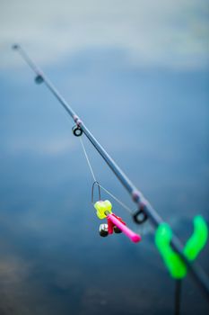 Freshwater fishing with fishing rods on the shore of the pond, lake