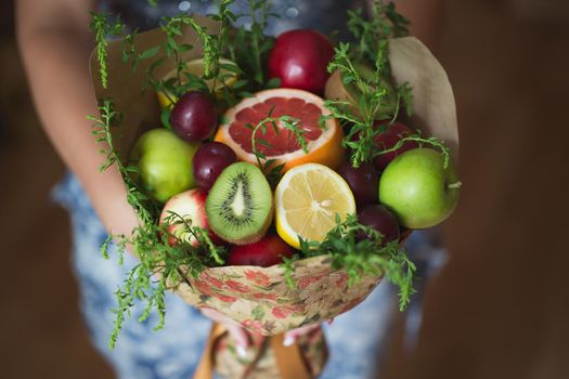 The original unusual edible bouquet of vegetables and fruits in the girl hands