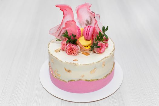 Beautiful cake with strawberries and almond cookies on a white table