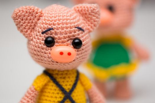 Knitted piglets toys for a child. A symbol of the New Year.