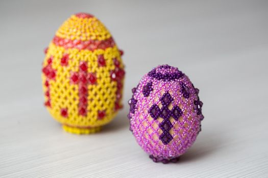 Eggs decorated with small beads on a white table