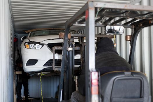 Unloading a broken car from a container