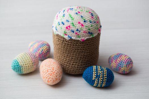 Knitted Easter eggs, chicken, cock on a white table
