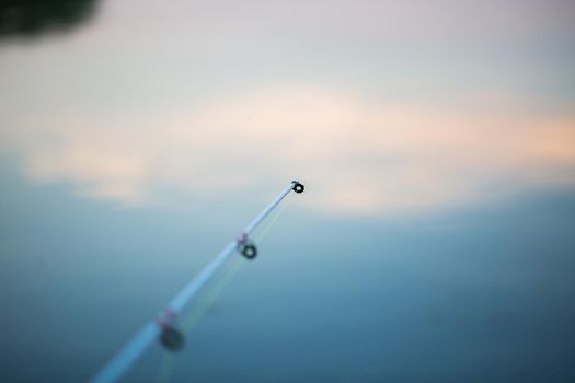 Freshwater fishing with fishing rods on the shore of the pond, lake