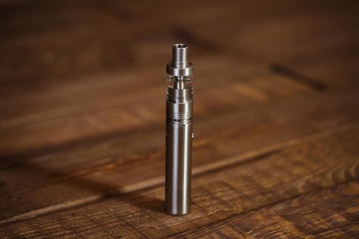 Electronic cigarette on a wooden table. Smoke.