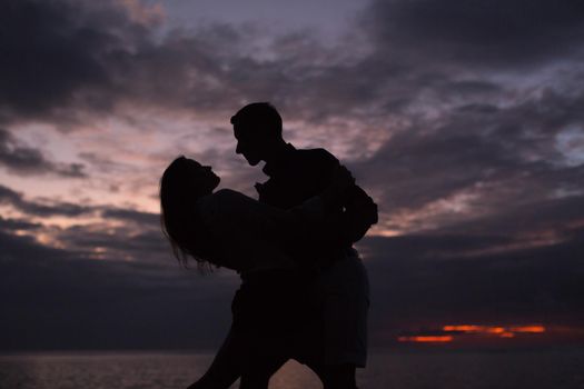 Silhouette of a dancing couple at sunset