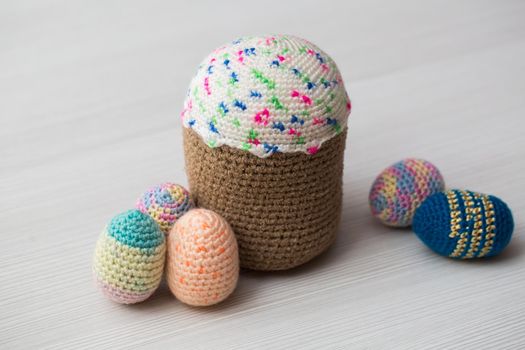 Knitted Easter eggs, chicken, cock on a white table