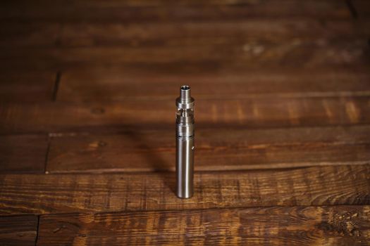 Electronic cigarette on a wooden table. Smoke.