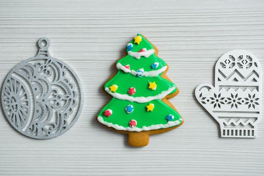 Christmas, new years decor on a wooden white background. Gingerbread mitten, a ball, lump, nut.