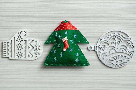 Christmas, new years decor on a wooden white background. Tree, glove, ball.