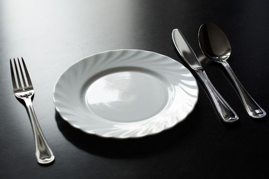 Cutlery on a black background. Fork, spoon, knife plate