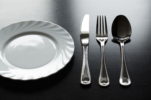 Cutlery on a black background. Fork, spoon, knife plate