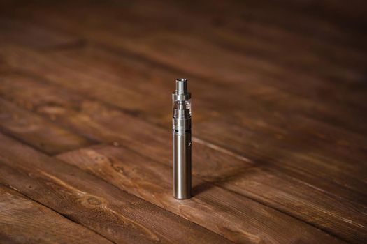 Electronic cigarette on a wooden table. Smoke.