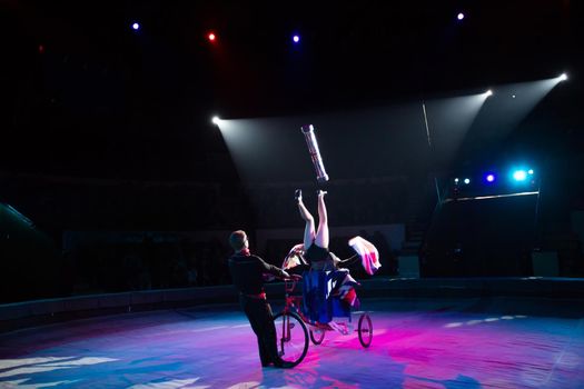 A juggler on a bicycle under the dome of the circus