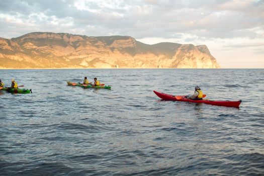 Kayaks. Canoeing in the sea near the island with mountains. People kayaking in the ocean.