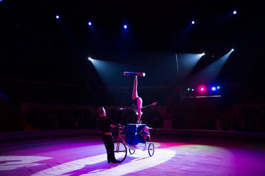 A juggler on a bicycle under the dome of the circus