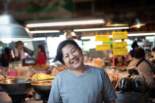 Woman at Thai street food with curry and rice shop in market