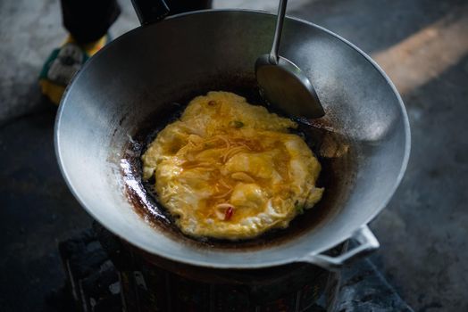 Thai style omelet is a Thai food make from egg cooking in pan with oil in Thai street food restaurant, healthy food concept