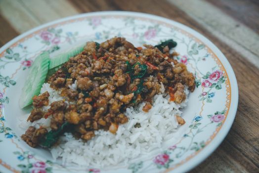 Rice topped with stir-fried pork or beef and basil for sale at Thai street food market or restaurant in Bangkok Thailand