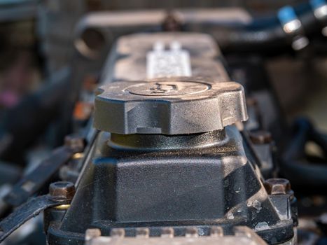 Filler cap for filling engine oil into a car engine. Engine oil filling point. Service service. Car maintenance and repair. Repair service workshop. Motor vehicle. Part of the car.