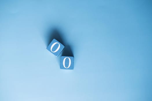 number zero on wooden block on blue background .