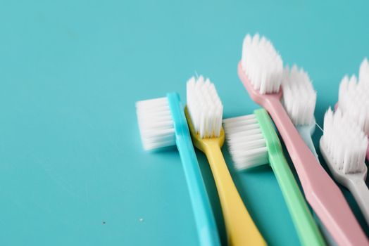 colorful toothbrushes on light green background .