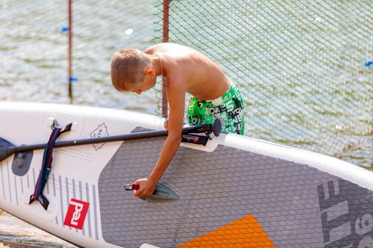 A child checks an inflatable rowing board before a competition. Russia Zelenograd 14 August 2021.