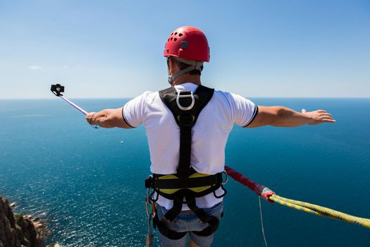 Rope jumping off a cliff with a rope in the water. The ocean. Sea. Mountain