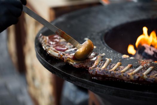 Grilled pork baby ribs with barbecue sauce on the grill. Festival street food