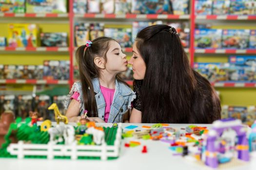 Mother with a little daughter playing with blocks