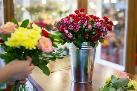 Workshop florist, making bouquets and flower arrangements. Woman collecting a bouquet of flowers