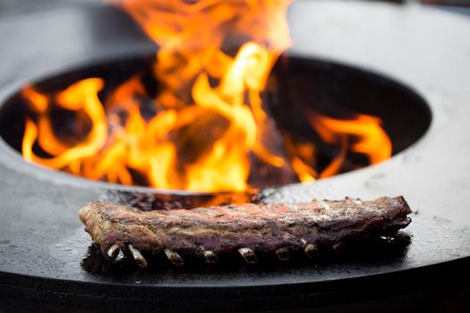 Grilled pork baby ribs with barbecue sauce on the grill. Festival street food